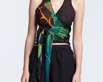 May include: A black halter top with a colorful floral print. The top is tied at the waist and has a V-neckline.