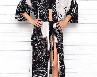 May include: A black and white long robe with a map print. The robe has a tie closure at the waist and long sleeves.