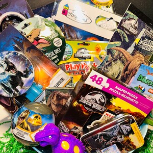 May include: A gift basket filled with Jurassic World themed toys and activities. The basket includes a dinosaur shaped stress ball, a sticker activity surprise, a shaped puzzle, a play pack, a coloring book, and a sticker and color activity book.