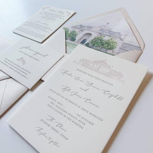 May include: Elegant wedding invitation suite in cream with embossed text. Includes invitation, RSVP card, and envelope with a watercolor illustration of a building. The invitation reads "Kobe & Kyla" and the date.