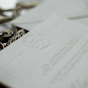 The Everly Suite. Letterpress Wedding Invitation. Elegant Subtle Wreath Monogram. Script Blind Impression Invite. White Cotton Paper. Sample