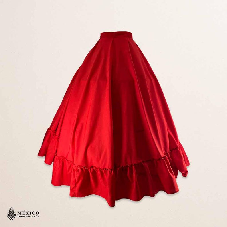 May include: A vibrant red full-length skirt featuring a high waistband and a voluminous, pleated silhouette. The hem is finished with a wide, gathered ruffle detail that adds texture and movement to the solid-colored garment.