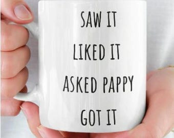 May include: White ceramic mug with black text that reads "Saw it, Liked it, Asked Pappy, Got it".