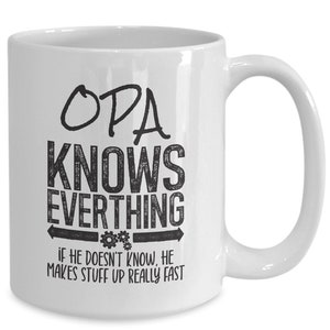 May include: White ceramic mug with the text "OPA KNOWS EVERTHING" in black, with the additional text "IF HE DOESN'T KNOW, HE MAKES STUFF UP REALLY FAST". The mug has a curved handle and is suitable for hot or cold beverages.