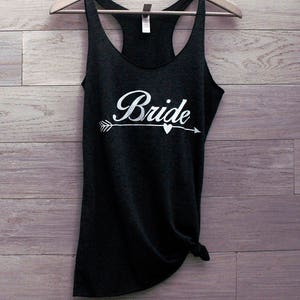May include: A black tank top with a white arrow and heart design and the word "Bride" in a cursive font.