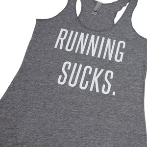 May include: Gray tank top with the text "RUNNING SUCKS." printed in white.