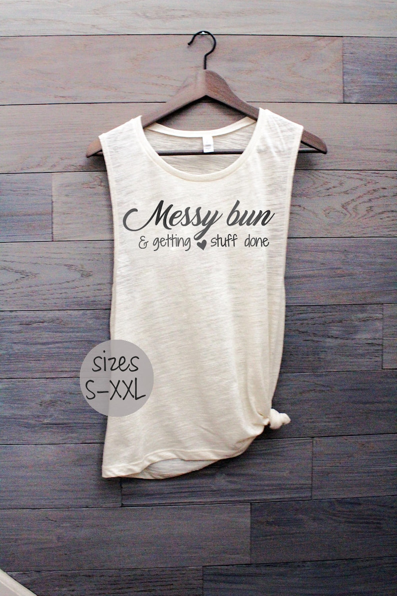 Pode incluir: Um top branco sem mangas com o texto "Messy bun & getting stuff done" em preto. O top tem uma parte inferior amarrada e est&aacute; dispon&iacute;vel nos tamanhos S-XXL.