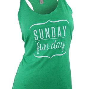 Op de afbeelding: Een groen tanktop met een witte afbeelding waarop "SUNDAY fun day" staat in een decoratief kader.