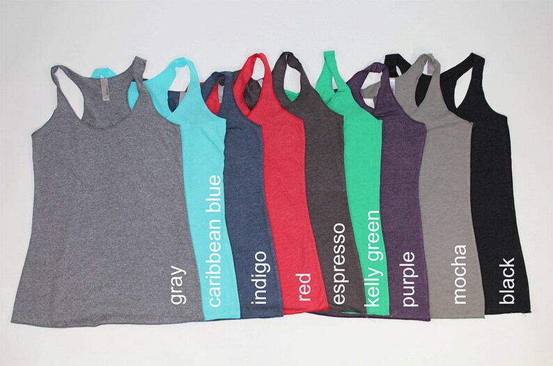 May include: A row of ten racerback tank tops in various colors, including gray, caribbean blue, indigo, red, espresso, kelly green, purple, mocha, and black.