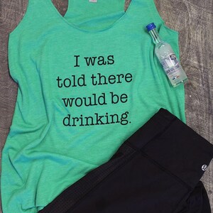 May include: A green tank top with the text "I was told there would be drinking." A small bottle of vodka is on the right side of the tank top.