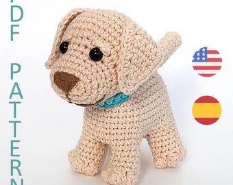 May include: Crocheted cream-colored Labrador puppy with brown nose and black eyes. The puppy is wearing a light blue collar. The image includes the text "PDF PATTERN" in teal.
