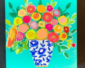 May include: A square painting on a turquoise background featuring a bouquet of colorful flowers in a white vase with blue floral patterns. A small yellow bird is perched on the left side of the arrangement among green leaves.
