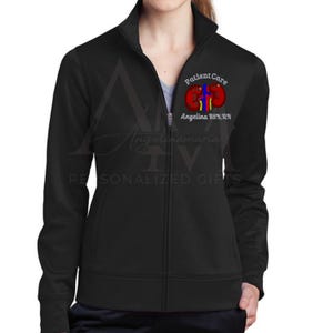 May include: Black zip-up jacket with a high collar. The jacket features a colorful kidney graphic with the words "Patient Care" and "Angelina BSN, RN" printed on the upper left chest. The jacket is a personalized gift.