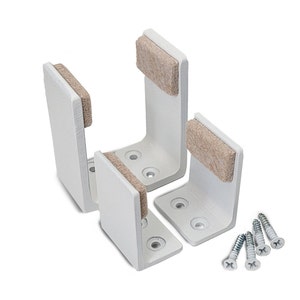 May include: Three white metal furniture leg brackets with felt pads and four silver screws. The brackets are designed to be attached to the bottom of furniture legs to protect floors.