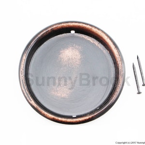 May include: A round, copper-colored metal plate with a smooth, black surface. The plate has a small hole in the center and is designed to be used as a decorative accent or a functional piece for crafts.
