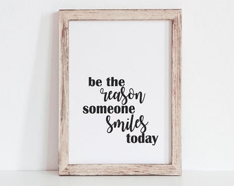 Puede incluir: Una impresión enmarcada con fondo blanco y texto negro que dice "be the reason someone smiles today". La impresión está colgada en una pared blanca en un comedor.