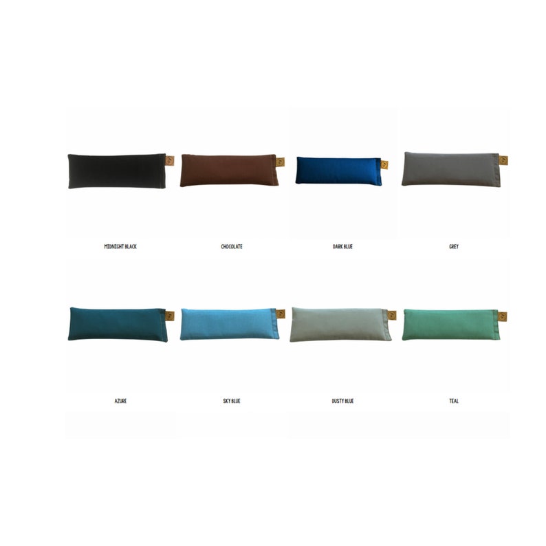 Puede incluir: Una colecci&oacute;n de almohadas rectangulares de colores lisos en varios tonos, incluyendo negro, marr&oacute;n, azul y verde. Cada almohada tiene una peque&ntilde;a etiqueta rectangular en un extremo. Los colores son Midnight Black, Chocolate, Dark Blue, Grey, Azure, Sky Blue, Dusty Blue y Teal.