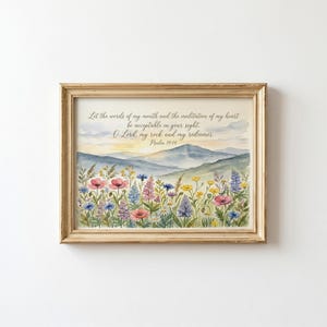 May include: A framed watercolor print featuring a landscape of rolling blue mountains under a soft sky, with a foreground of colorful wildflowers. The text reads: Let the words of my mouth and the meditation of my heart be acceptable in your sight. O Lord, my rock and my redeemer. Psalm 19:14.