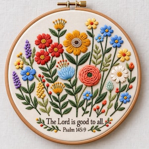 Peut inclure: Un tambour à broder circulaire en bois contenant un tissu crème avec un arrangement floral brodé à la main composé de fleurs rouges, jaunes, bleues et orange avec des feuilles vertes. Le texte "The Lord is good to all. Psalm 145:9" est brodé.