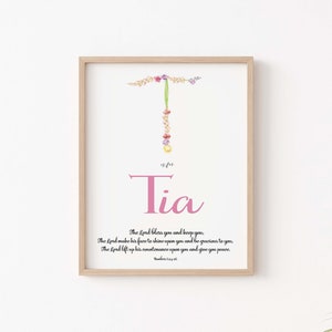 Può includere: Un design di arte da parete stampabile con il nome "Tia" in corsivo rosa con una lettera "T" floreale e un versetto biblico da Numeri 6:24-26. Il versetto recita: "Il Signore ti benedica e ti custodisca. Il Signore faccia brillare il suo volto su di te e ti sia propizio. Il Signore alzi il suo volto su di te e ti dia pace."