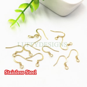 May include: Gold-toned earring hooks made of stainless steel. The hooks are designed with a small loop at the top and a curved wire that forms a hook.