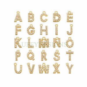 Op de afbeelding: Gouden alphabet letter charms met heldere kristallen versieringen. Elke letter is een aparte bedel.