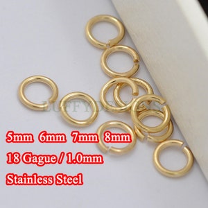 Op de afbeelding: Een close-up van een groep gouden springringen in verschillende maten, 5 mm, 6 mm, 7 mm en 8 mm. De ringen zijn gemaakt van 18 gauge roestvrij staal.