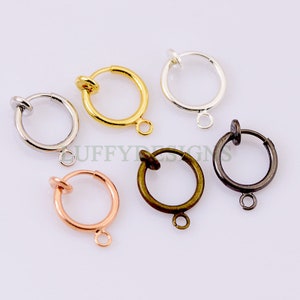 May include: Six different colored non-pierced earring hoops. The hoops are made of metal and have a clip-on closure. The colors are gold, silver, rose gold, black, and two shades of bronze.