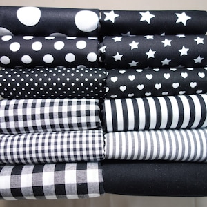 Può includere: Un mucchio di dieci quadrati di tessuto in motivi bianco e nero. I motivi includono pois, stelle, cuori, gingham e strisce.