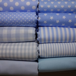 Può includere: Un mucchio di dieci quadrati di tessuto in vari motivi blu e bianchi. I motivi includono pois, stelle, strisce e gingham.