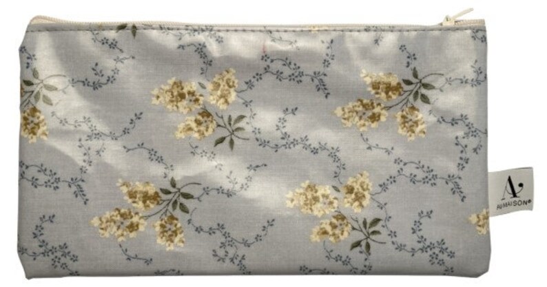 May include: A light blue zippered pouch with a floral pattern of small yellow flowers and green leaves. The pouch has a white zipper and a small white label with the text "A. HARRISON" on it.