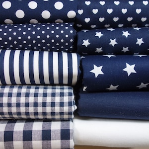 Könnte beinhalten: Ein Stapel von acht Stoffproben in verschiedenen marineblauen und weißen Mustern. Die Muster umfassen Punkte, Herzen, Sterne, Streifen und Gingham.