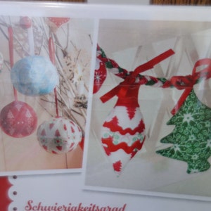 Könnte beinhalten: Weihnachtsschmuck in verschiedenen Formen und Mustern. Das Bild zeigt runde Kugeln mit rot-weißen Mustern, eine hellblaue Kugel und eine Girlande mit rot-weißen tropfenförmigen Ornamenten und einem grünen Weihnachtsbaumschmuck.