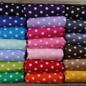 Può includere: Un rotolo di tessuto con stelle bianche su sfondo colorato. I colori includono blu navy, blu, azzurro, turchese, lavanda, rosa, rosso, arancione, giallo, marrone, grigio e verde.