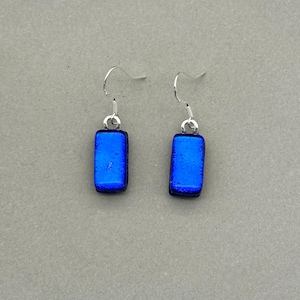 Könnte beinhalten: Ein Paar blaue rechteckige Glas-Hängeohrringe mit silbernen Haken.