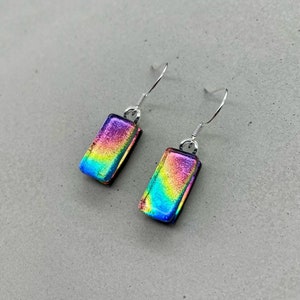 May include: A pair of iridescent rainbow glass rectangle earrings with silver hooks.