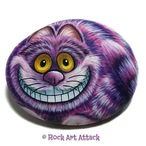Gato morado de dibujos animados pintado a mano sobre una piedra pequeña. Pintado con acrílicos y acabado con barniz protector satinado. Cuadro de gato de dibujos animados.