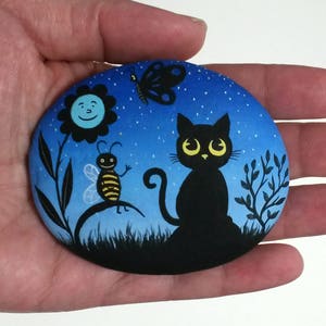Stone Painting Silhouette of a Bee, Butterfly, Sunflower and Cat on the NIght! Painted with Acrylic paints and finished with Satin varnish