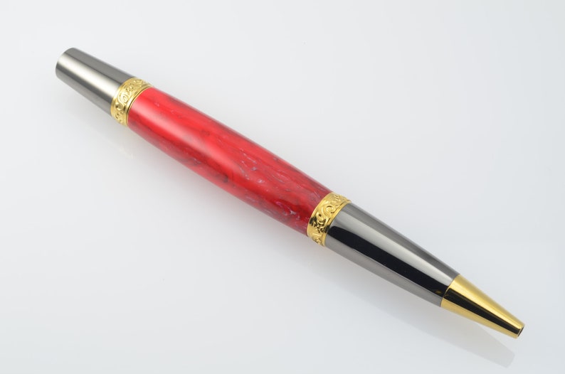 May include: A red and black pen with gold accents. The pen has a marbled red body and a black metal tip with a gold band.
