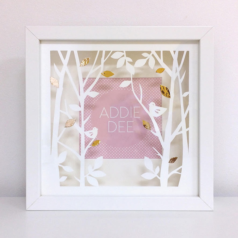 May include: White frame with a cutout design of trees and leaves. The frame has a pink background with white polka dots and the text "ADDIE DEE" in a circle. There are gold accents throughout the design.
