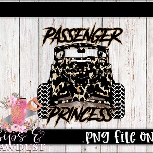 May include: A black and brown graphic of a side-by-side vehicle with the text "Passenger Princess" in gold lettering. The vehicle is decorated with a leopard print pattern.