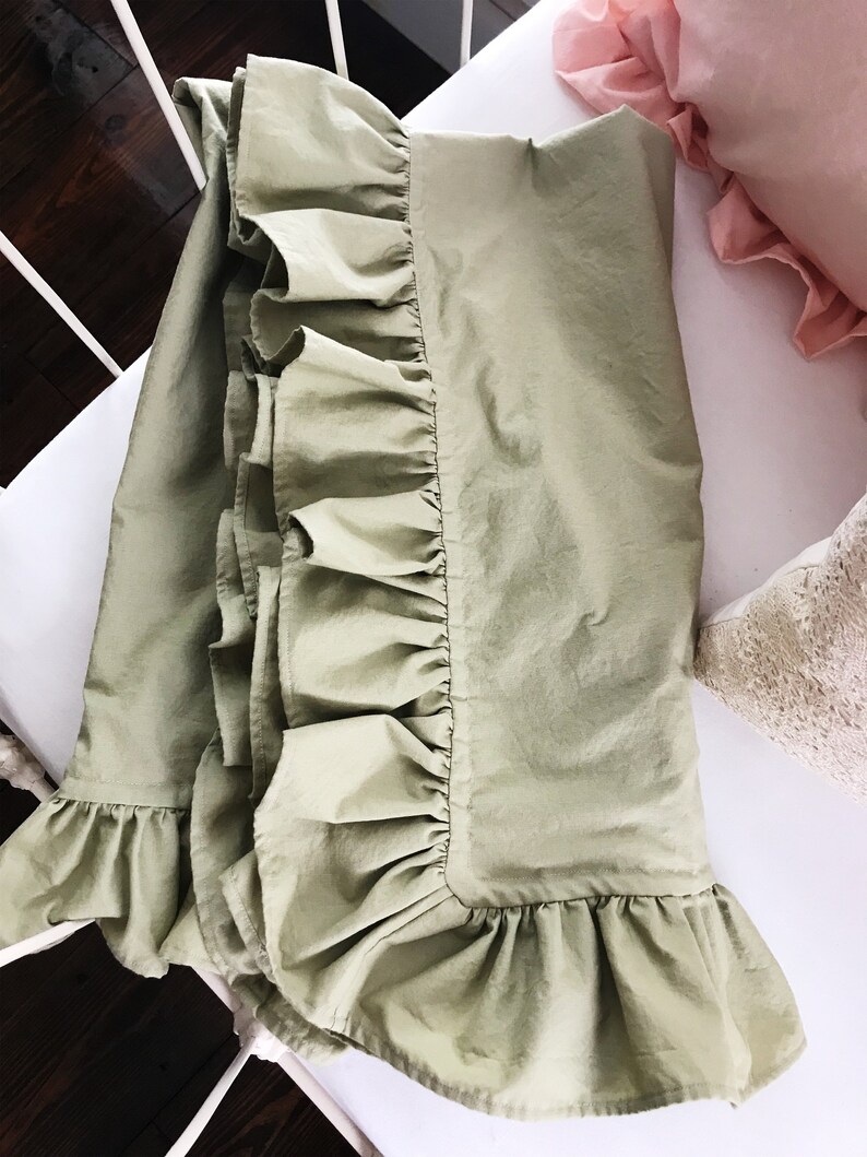 Puede incluir: Una falda de cama de color verde salvia con un borde de volantes. La falda est&aacute; hecha de una tela suave y ligera, perfecta para agregar un toque de elegancia a cualquier dormitorio.