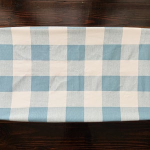 May include: A blue and white gingham changing pad cover. The cover is made of a soft, comfortable fabric and is perfect for protecting your changing pad from spills and messes.