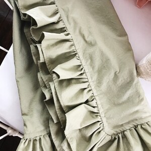 Puede incluir: Una falda de cama de color verde salvia con un borde de volantes. La falda est&aacute; hecha de una tela suave y ligera, perfecta para a&ntilde;adir un toque de elegancia a cualquier dormitorio.