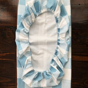May include: A blue and white checkered fitted sheet for a crib or bassinet. The sheet is made of soft, breathable fabric and is perfect for keeping your baby comfortable and cozy.
