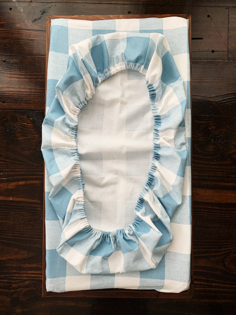 May include: A blue and white checkered fitted sheet for a crib or bassinet. The sheet is made of soft, breathable fabric and is perfect for keeping your baby comfortable and cozy.