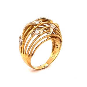 May include: A gold ring with a delicate design of interwoven bands and small diamonds. The ring is set with a total of 7 diamonds.