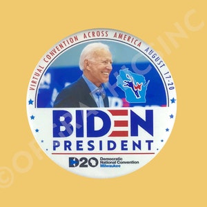 May include: A round button with the text "BIDEN PRESIDENT" in blue and red. The button also features an image of Joe Biden, the text "VIRTUAL CONVENTION ACROSS AMERICA AUGUST 17-20", and a map of Wisconsin.