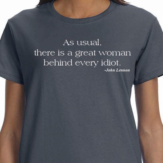 John Lennon Quote - As usual, there is a great woman behind every idiot. 100% Cotton T-Shirt.