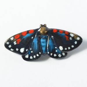 Broche de borboleta com inseto. Acessório de borboleta em preto, branco, vermelho e azul. Bijuteria artesanal de barro com mariposa, pronta para envio, 60 x 25 mm.